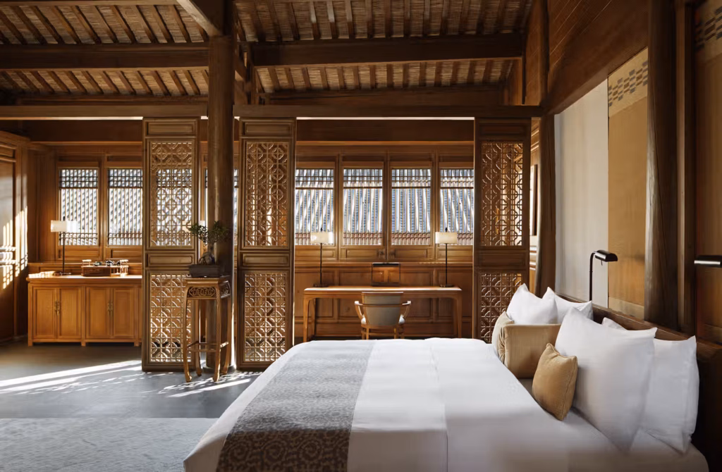 Legno dello Yunnan, architettura Naxi e grandi aperture sul paesaggio trasformano ogni sistemazione in un luogo da cui osservare Lijiang con calma.