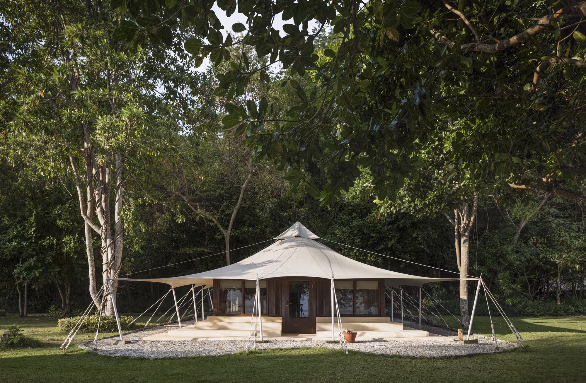 Sotto le ampie coperture in tela, legno e materiali naturali creano ambienti raccolti, mentre le terrazze private aprono lo sguardo sulla foresta o sulle acque del Mare di Flores. — immagine 1