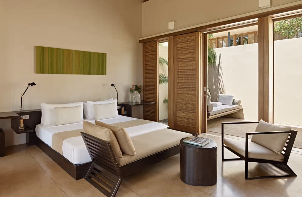 Grandi vetrate attraversano le suite da un lato all’altro, lasciando entrare la luce, le palme e l’oceano, mentre ogni sistemazione custodisce il proprio spazio esterno con plunge pool privata.