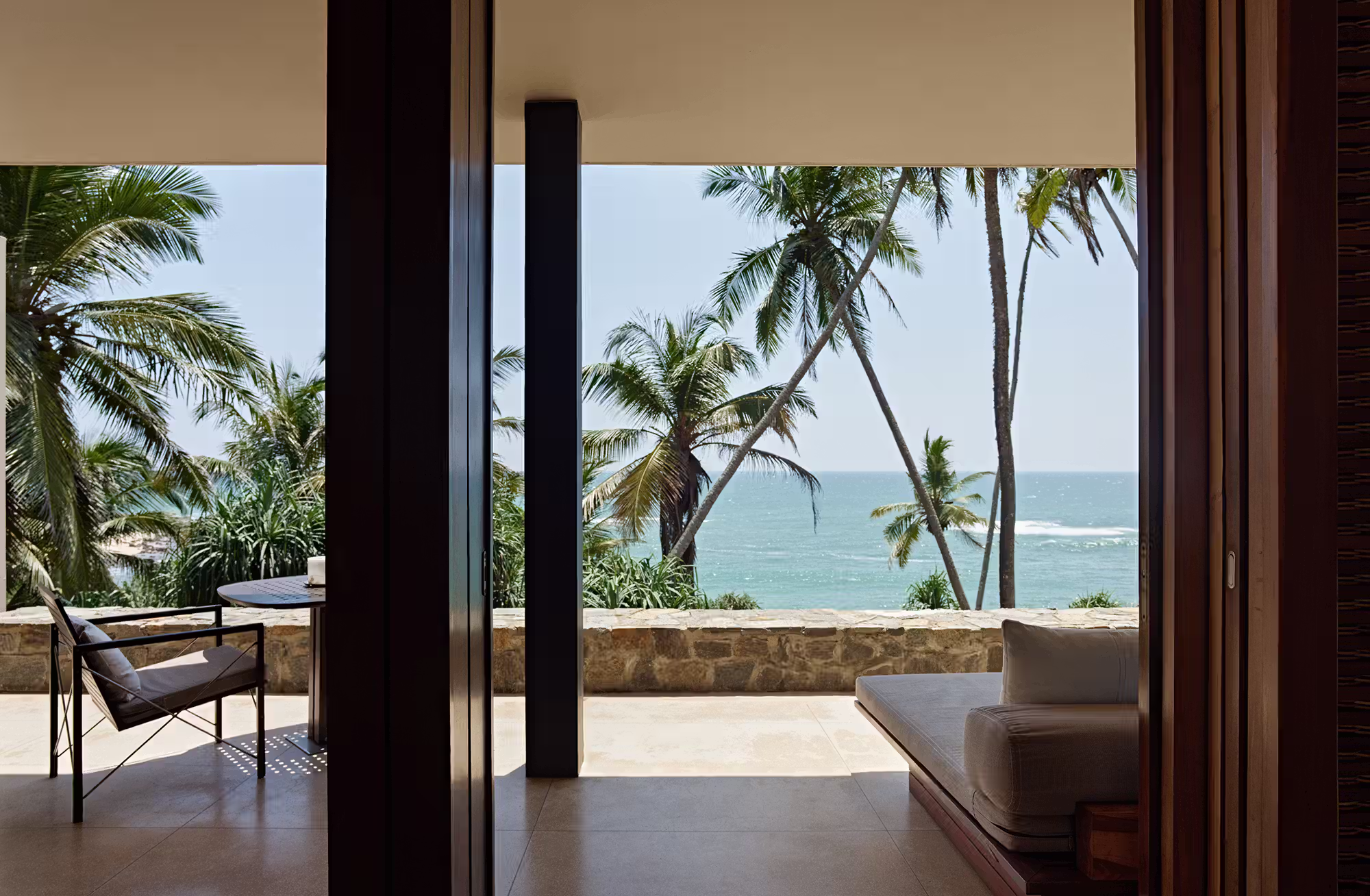 Grandi vetrate attraversano le suite da un lato all’altro, lasciando entrare la luce, le palme e l’oceano, mentre ogni sistemazione custodisce il proprio spazio esterno con plunge pool privata. — immagine 3